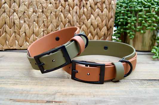 Two biothane dog collars, both Olive Green and Caramel on a wooden surface with a woven basket and plant in the background.