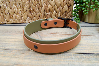 An Olive Green and Caramel biothane dog collar on a wooden surface with a woven basket and plant in the background.